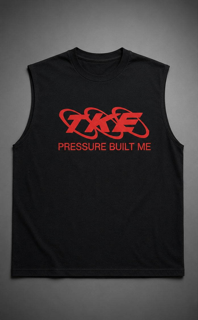 A black sleeveless muscle tank top with a red graphic logo and the text 'PRESSURE BUILT ME' on the chest, displayed against a black background 